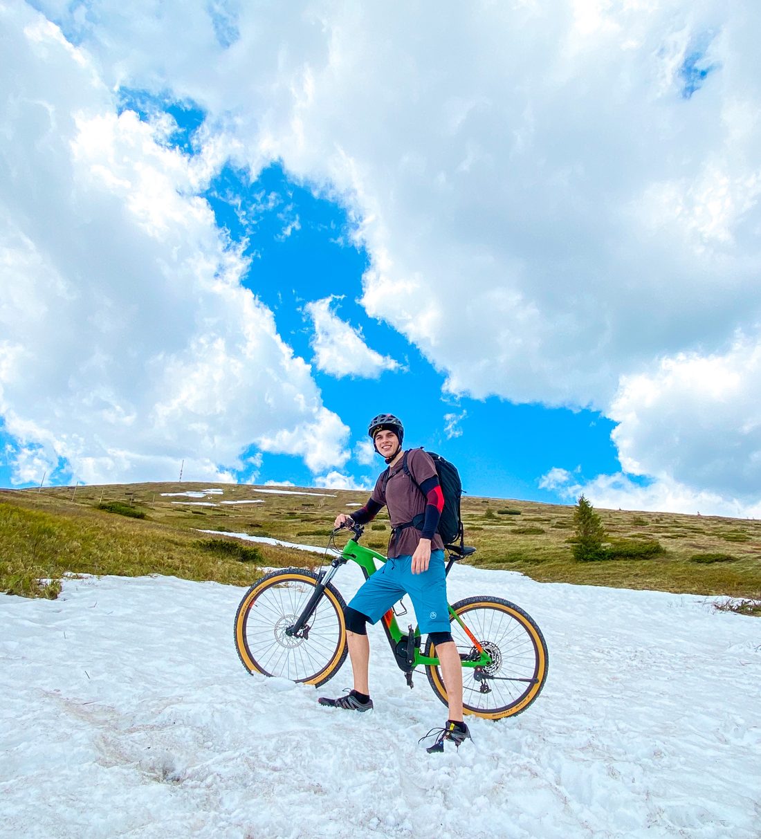 Bran Hrivnak with a mountain bike on a snow-covered ridge